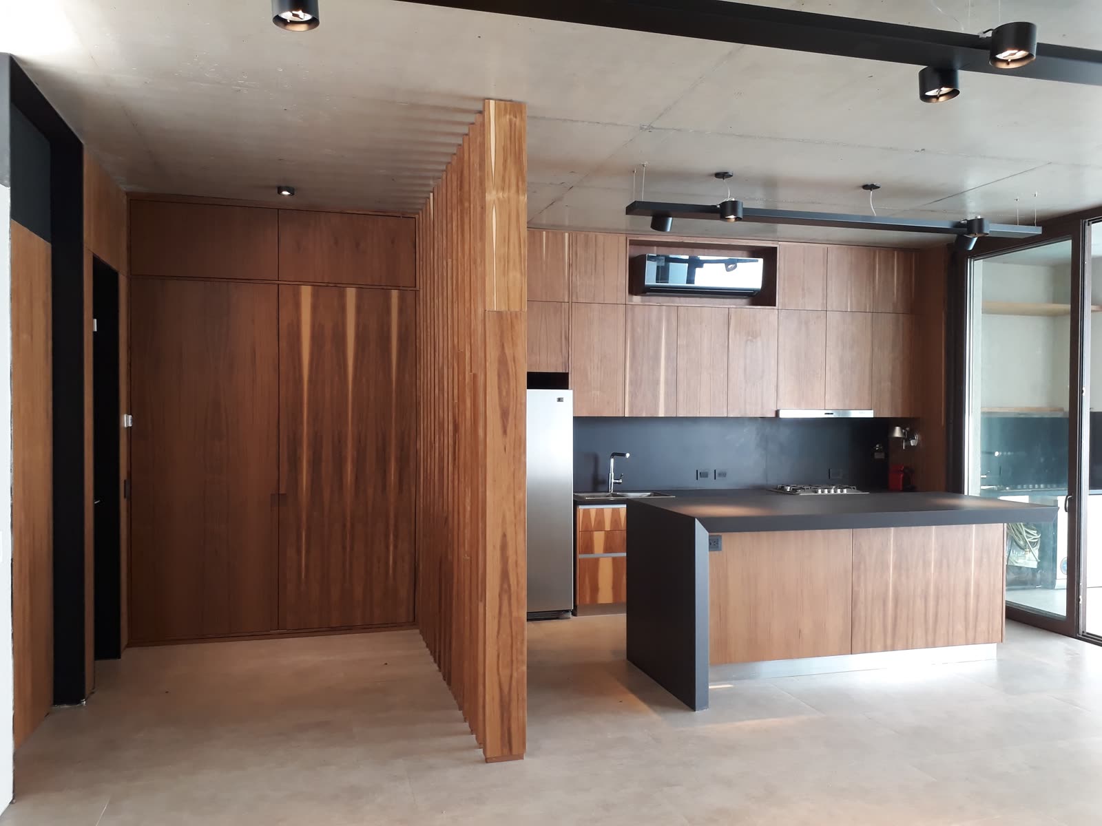 Cocina y living equipados en edificio de hormigón visto